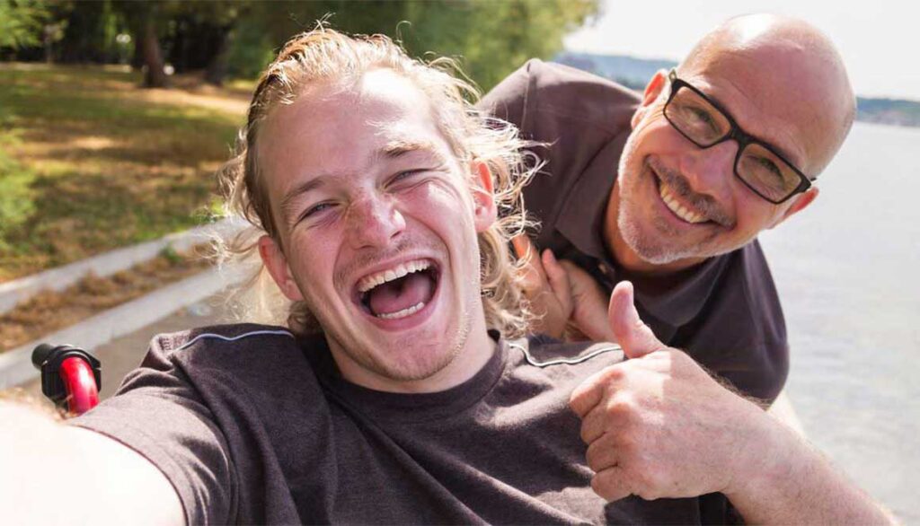 Assistenzkraft-begleitet-einen-Mann-im Rollstuhl-in-Erlangen